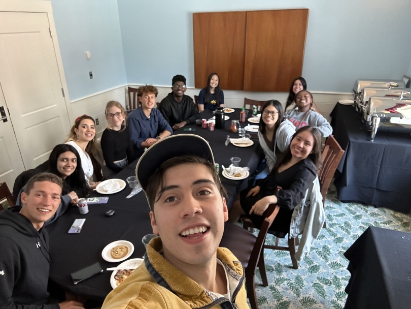 Student Nacho taking a selfie in the Tuck School of Business with two cohorts of Paganucci Fellows