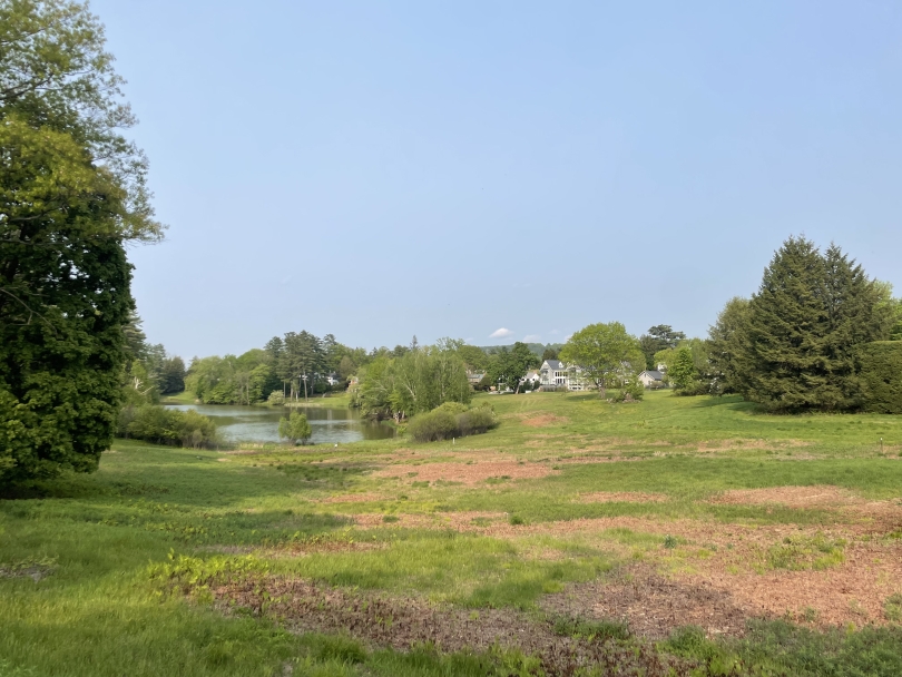 A wide open view of the adjacent field to Occom Pond on Dartmouth's campus on a bright, sunny day