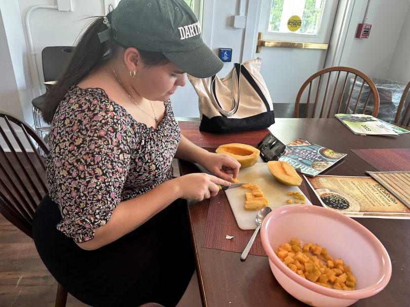Person cooking cantaloupe into small cubes