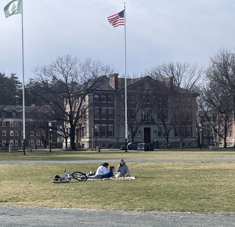 three Dartmouth students relaxing on the grass on the Dartmouth Green