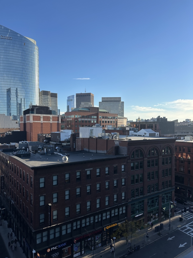 A scenic view of Boston with the city skyline in the distance, seen from an elevated vantage point.