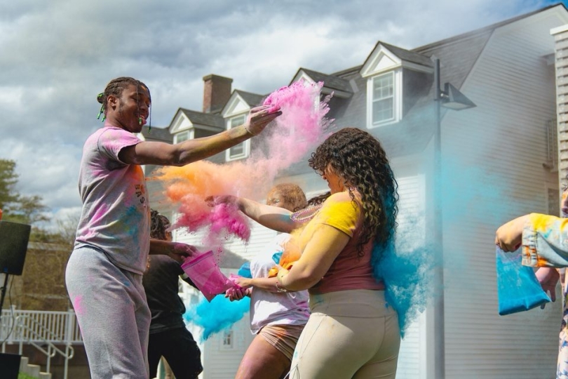 Two Dartmouth students throwing colorful powder at each other.