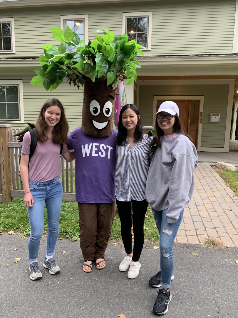 Diana '23, Jiyoung '23, and Abigail '23 smiling for photo with West House mascot