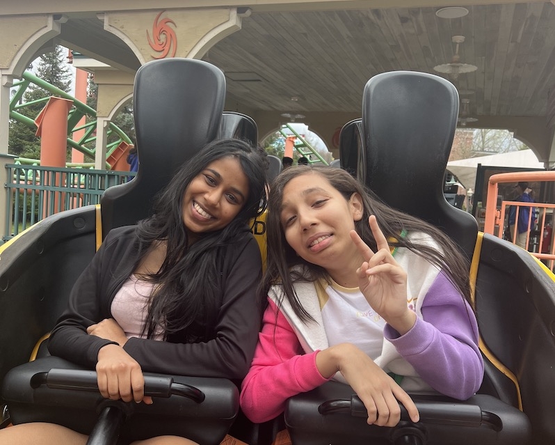 Two students on seats in a rollercoaster at the Six Flags amusement park.
