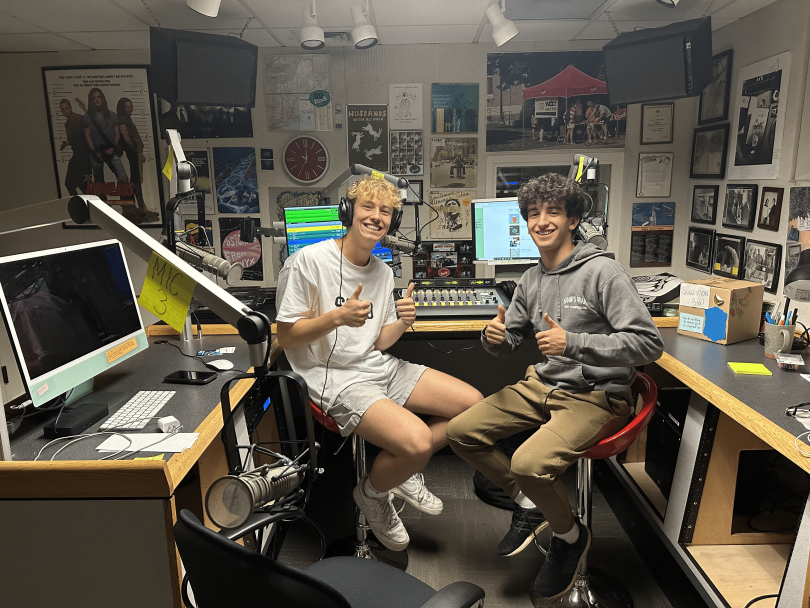 martin and his friend Daniel giving the thumbs up sitting in the radio booth at Dartmouth Radio Station