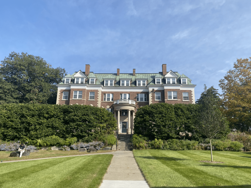 a view of richardson hall standing tall through the bushes below it