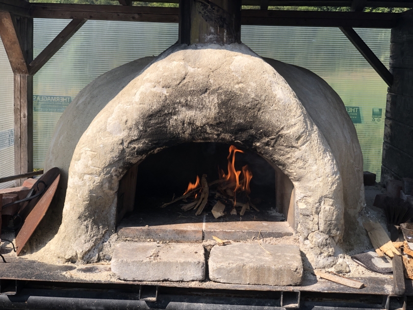 A close-up of an open, mortar pizza oven.