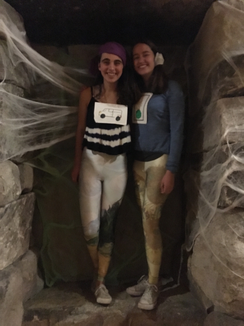 Sarah and Katrina in costume in front of spiderwebs