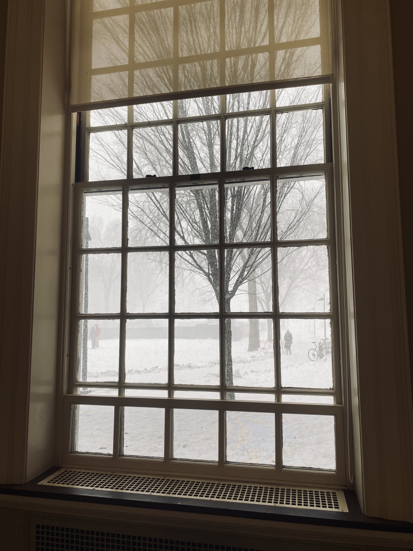 An image through one of Baker-Berry librariy's window of a snow-covered landscape