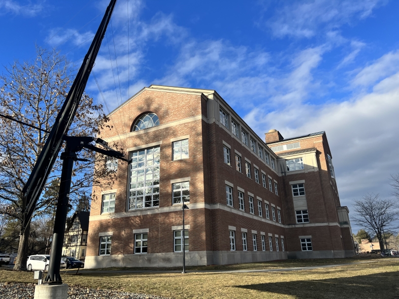 The same brick building, this time from the side. A massive solar panel blocks the view of part of the building.