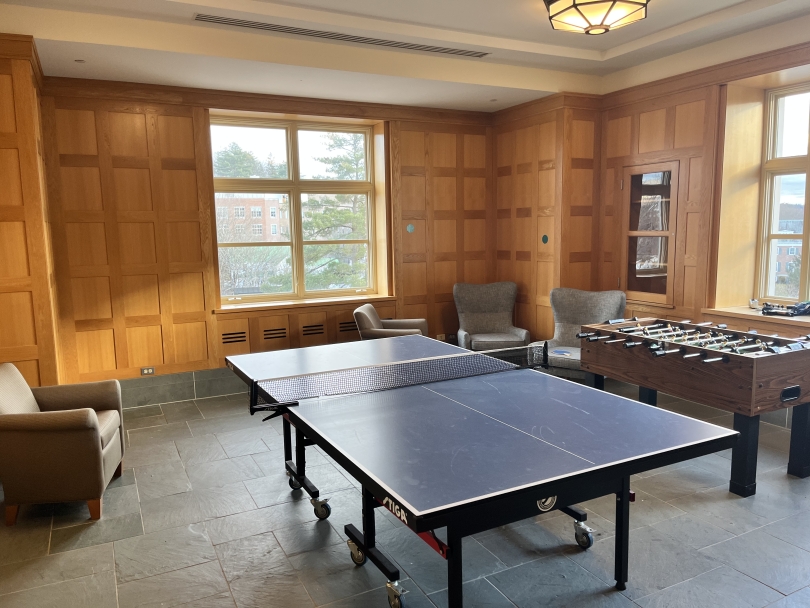 Another wooden room like the earlier seating area. This one has a few chairs, as well as a ping pong table and a foosball table