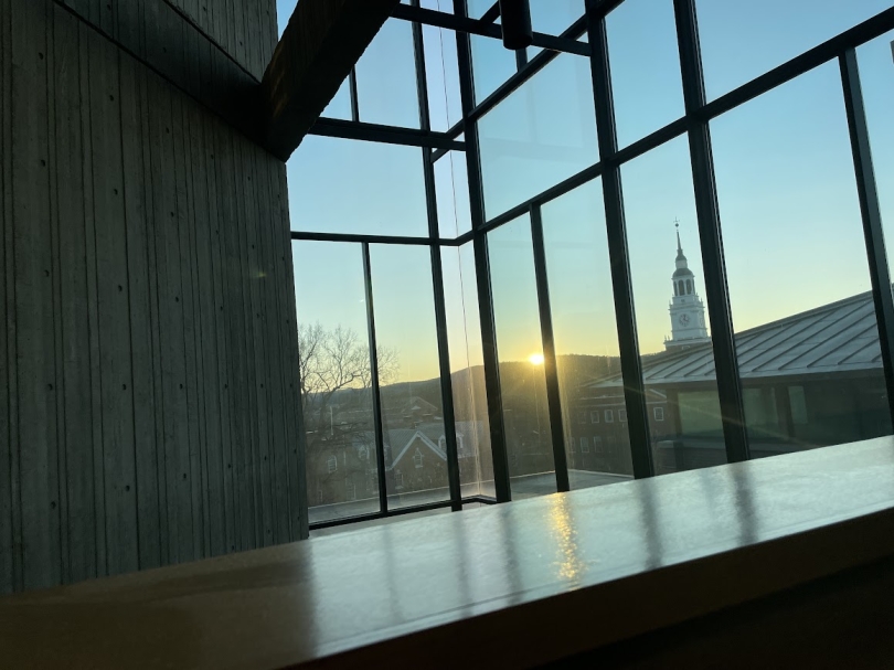 a picture of Baker Tower seen through the windows of Fairchild fourth floor when the sun is about to set behind the hills and is barely visible