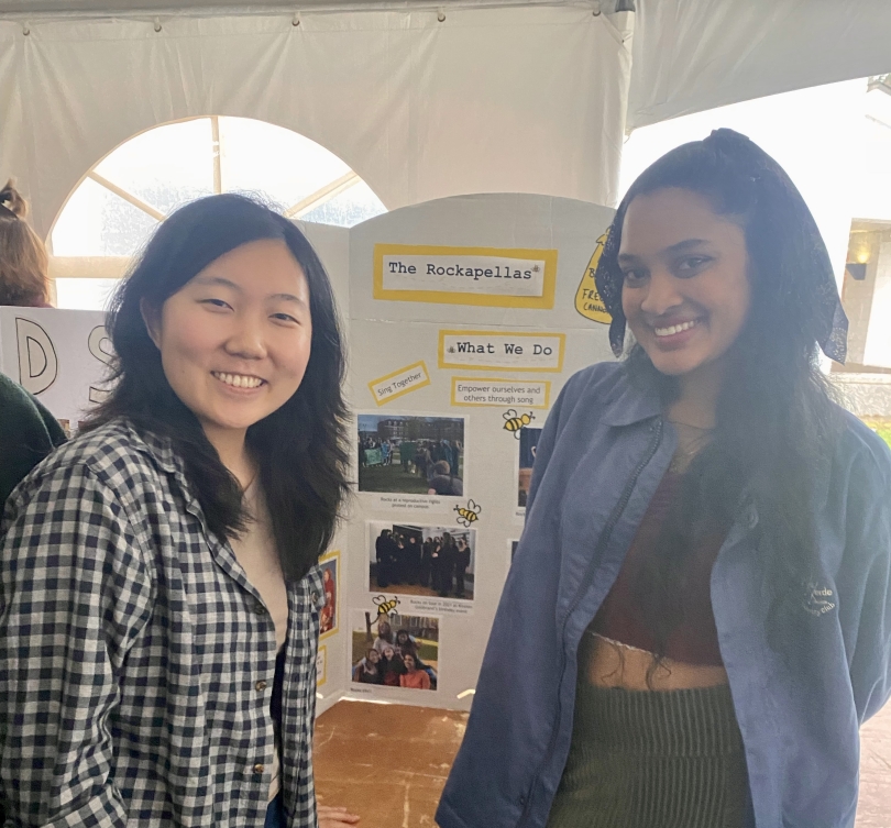 two women in front of a poster