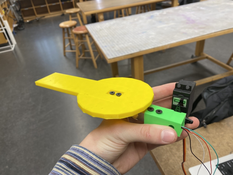 a plastic pad attached to a small servo motor, held in martin's hand