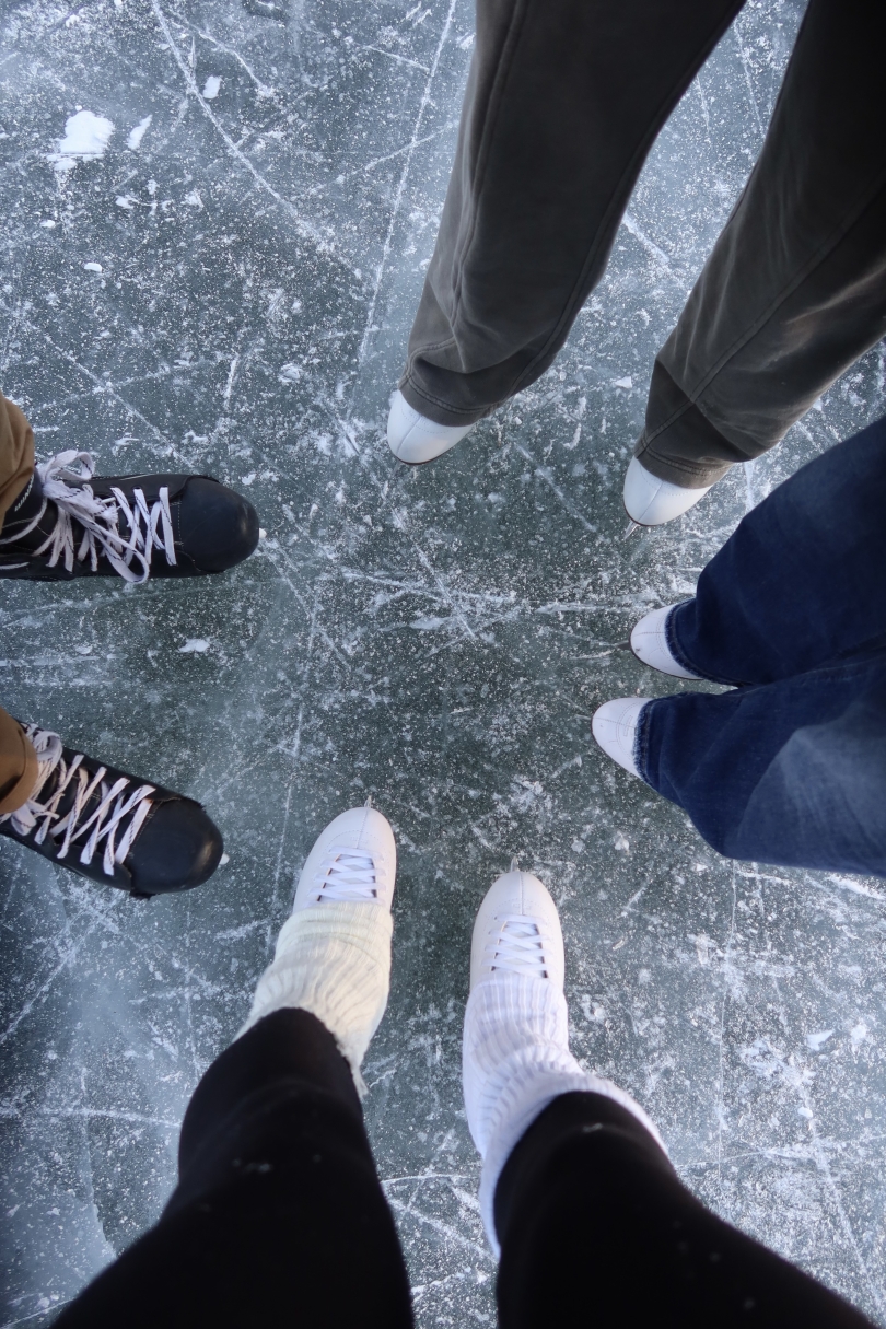 On the clear ice on occum pond, pairs of skate form a circle in the center of the image.