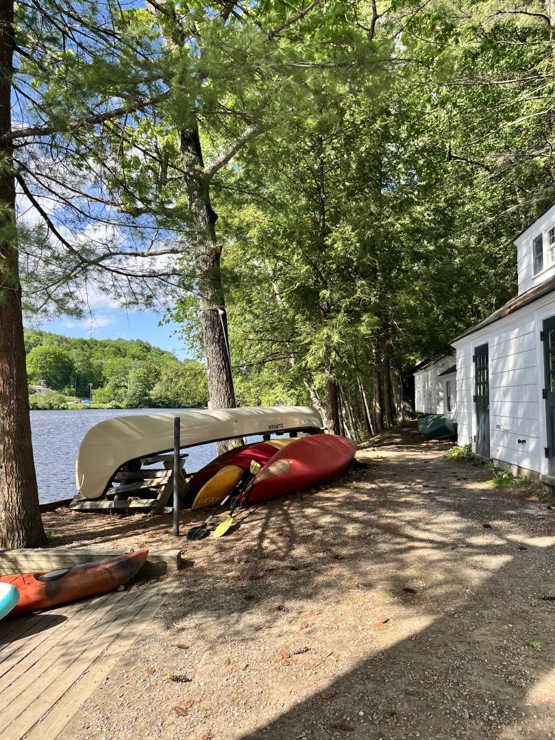 A photo of the Ledyard canoes and kayaks being stored near the river