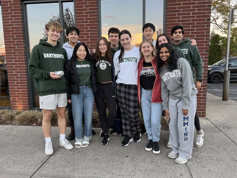 a picture of the dartmouth club swim team in front of chipotle. Martin stands to the left and they're all wearing this big green dartmouth merch proudly!