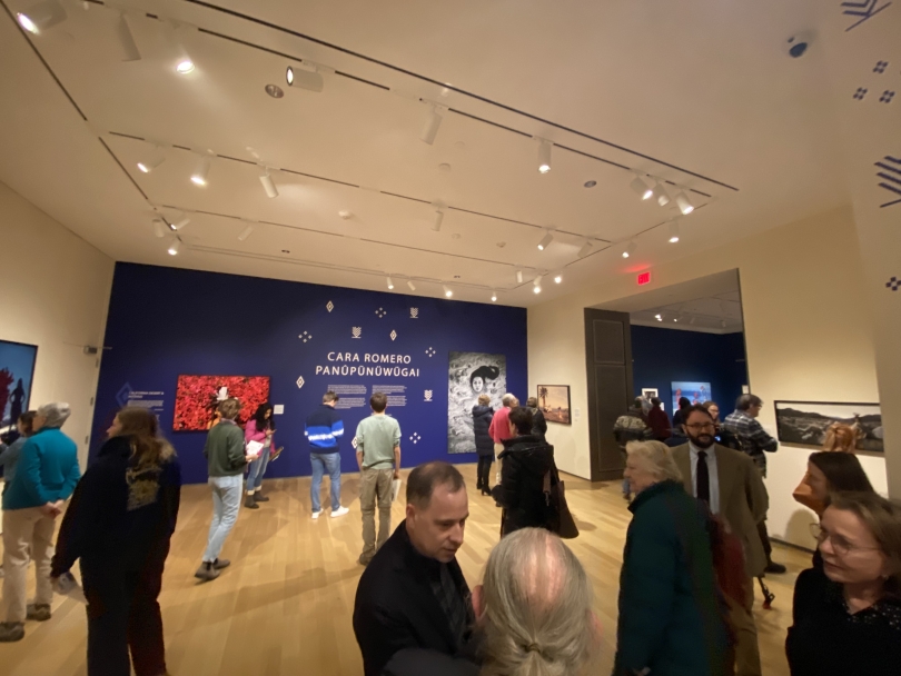 A landscape view of visitors in a warmly-lit art gallery in the Hood Museum