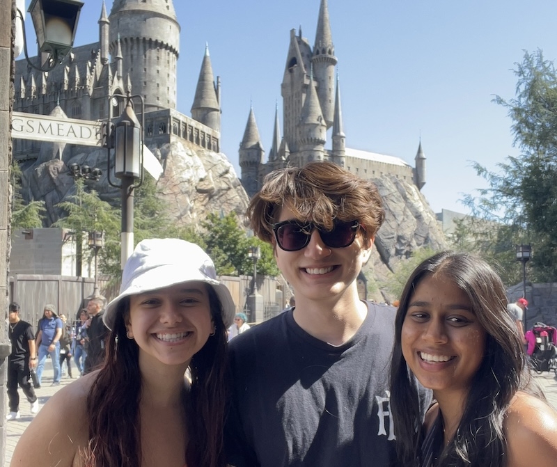 An image of three students in front of a model of Hogwarts Castle, Universal Studios