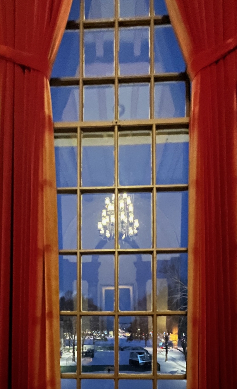 A view from a large Tower Room window at night. Snow is on the Green.