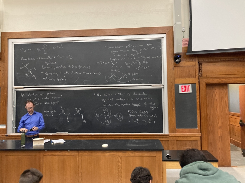 An image of Steele Hall Lecture Hall with a professor standing in front of a chalkboard