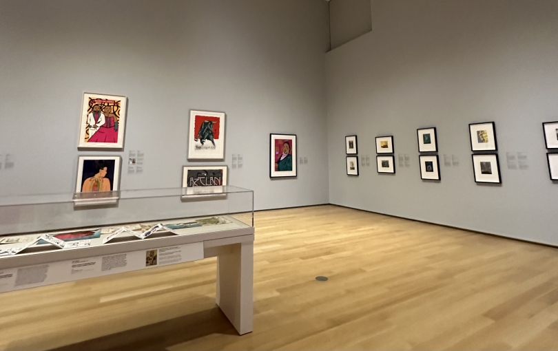 A gray wall holds a handful of portraits, decorating the museum's space.