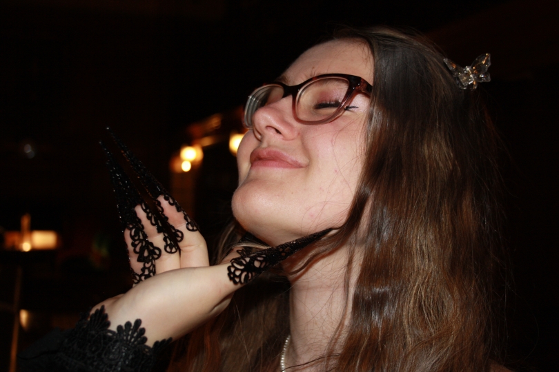 One of my friends face is the key part of this photo and another friend is delicately supporting her chin with costume nails that belong to a crow costume.