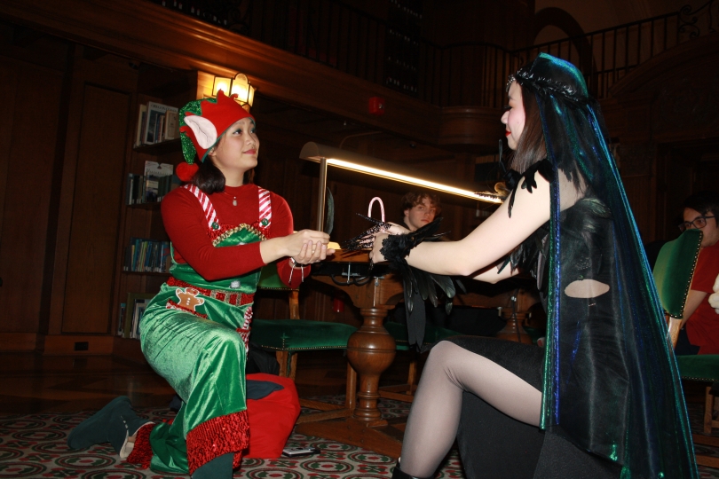 Two of my friends in the tower room with a reading light behind them mimicking the pose for rock, paper, scissors. 