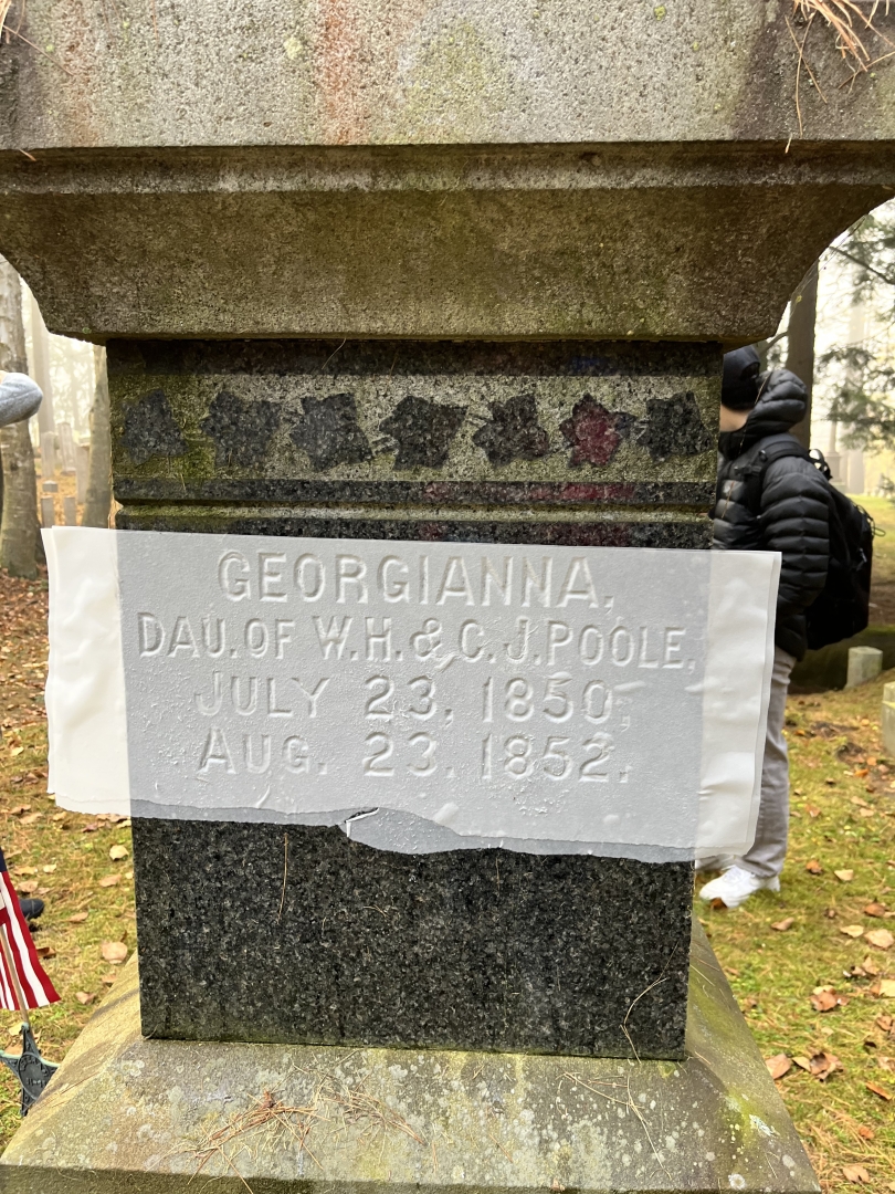 A photo of a squeeze I made with my partner on a headstone in the cemetery