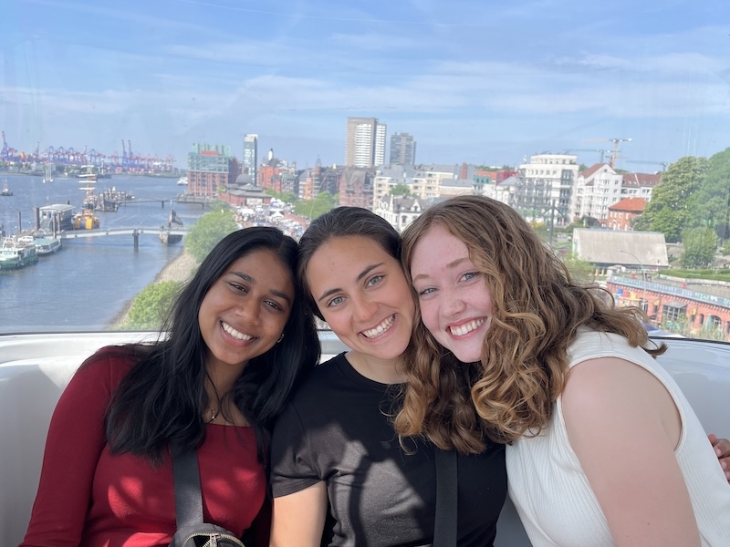 An image of three girls on a seat in Ferris wheel