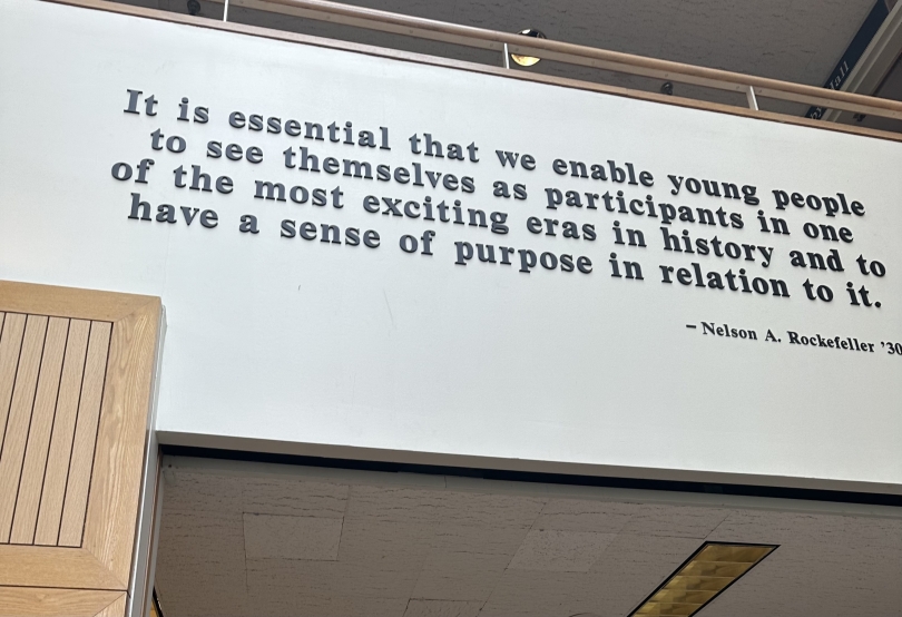 A quote on a white-painted wall frames a room connection in the Rockefeller Center.