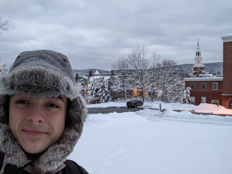 Selfie of me and a snowy background of Dartmouth's Campus