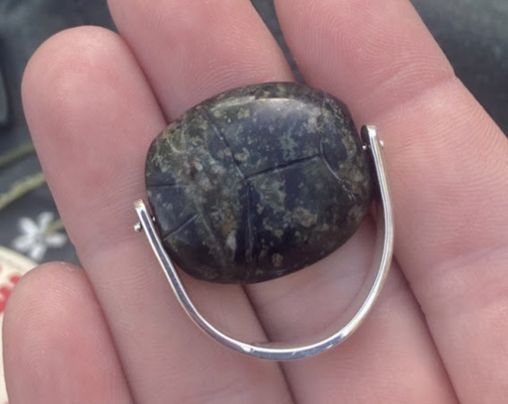 my finished ring, with a silver band, the domed/scarab side facing up, held in my hand