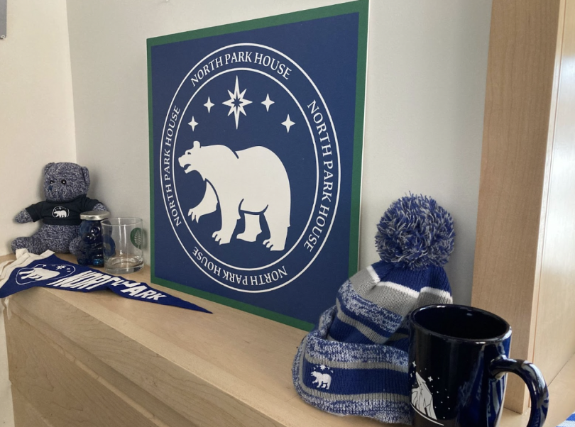 Blue banners, mugs, and hats with white North Park house logos on them.