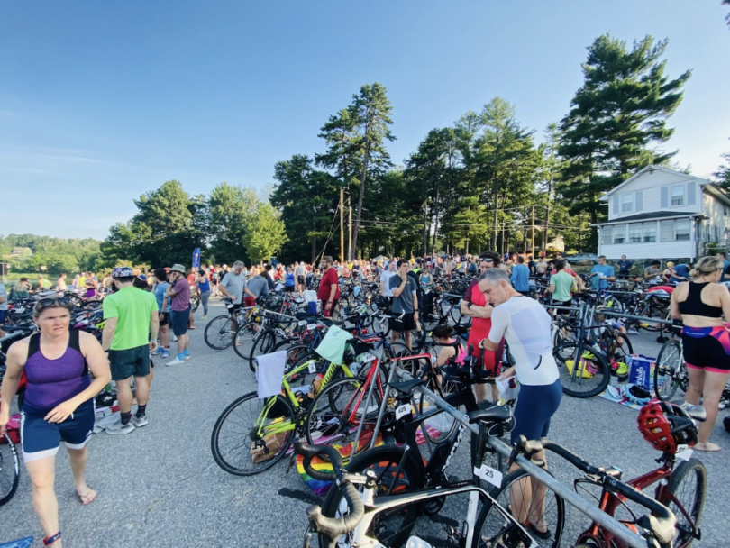 A panoramic shot of the transition zone, a place filled with athletes in neon race outfits parking their bikes.