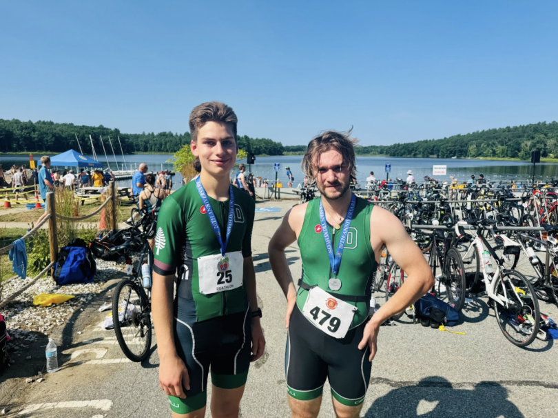 Frank and Nathan in Dartmouth Triathlon kit standing side by side in front of a lake.