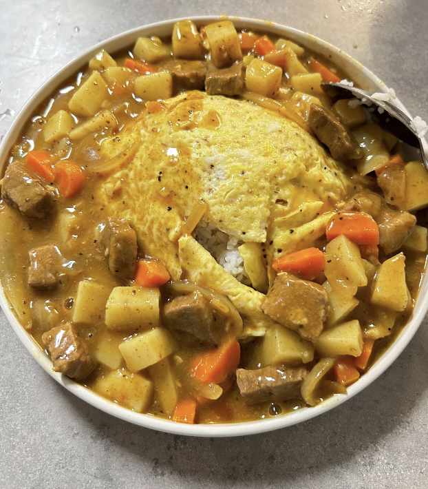 A picture of plated Japanese curry with rice omelet