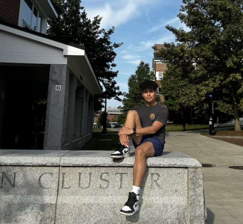Picture of Mario sitting on the sign in front of North Park's Mclaughlin Cluster