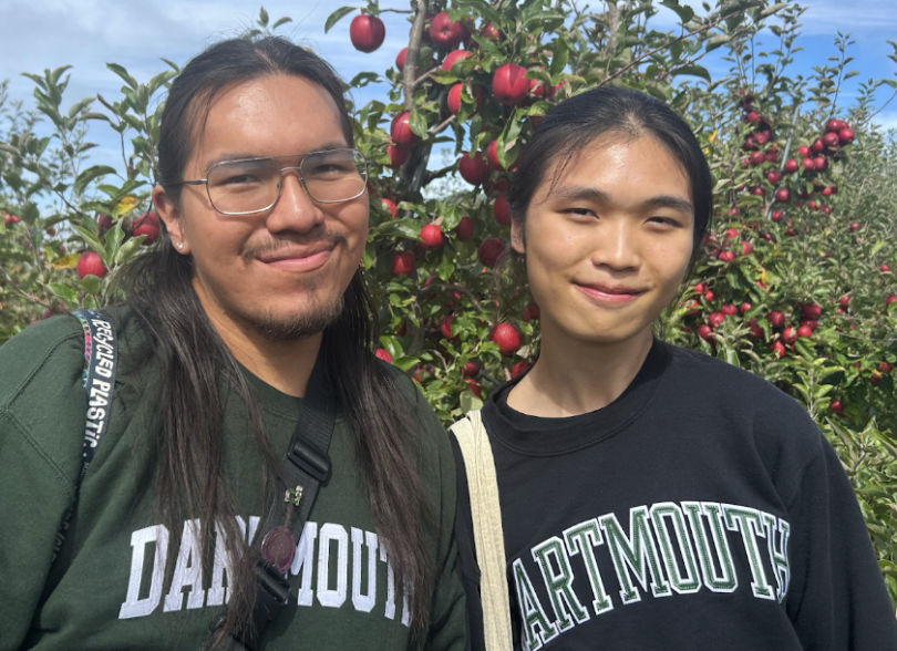 Oscar and Wica pose for a picture in front of an apple tree