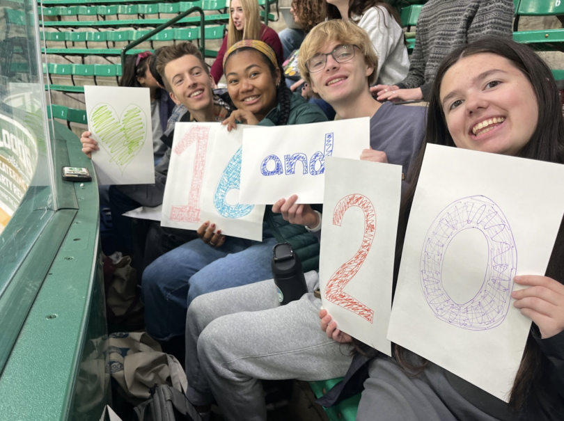 Four young adults smiling and holding signs that say "Love 16 and 20".