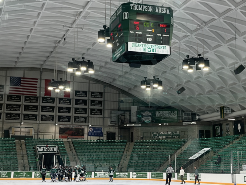 The green jerseyed hockey team celebrating on the ice and a scoreboard that says "Home: 6 Guest: 1"