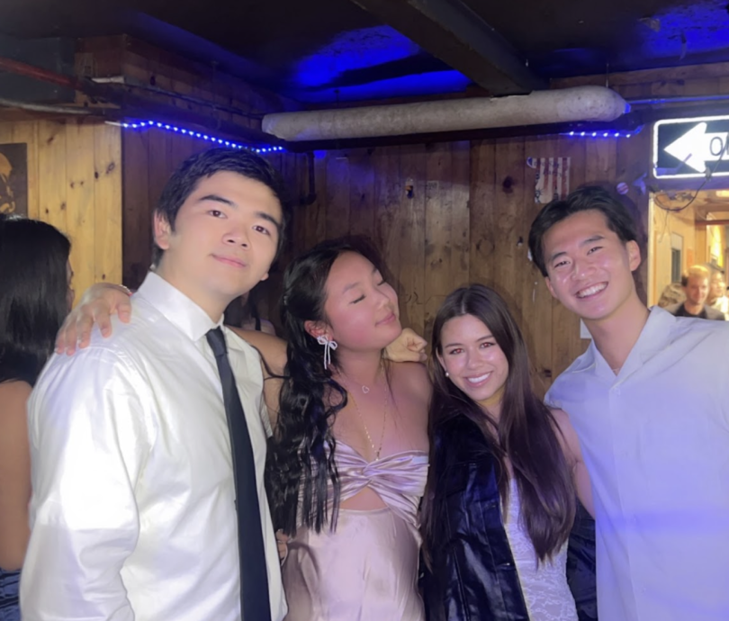 Madison standing and smiling with friends, wearing formal clothing.