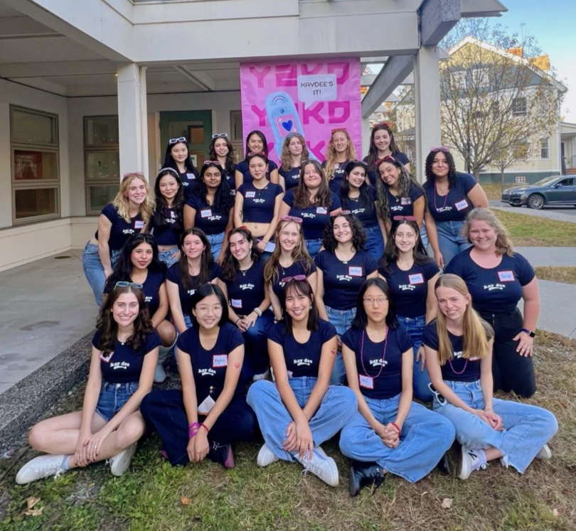 New members of KD posing outside of a building wearing matching shirts