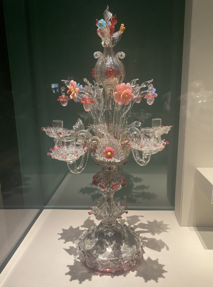 An ornate glass candleholder with pink floral and crystal details is on display.