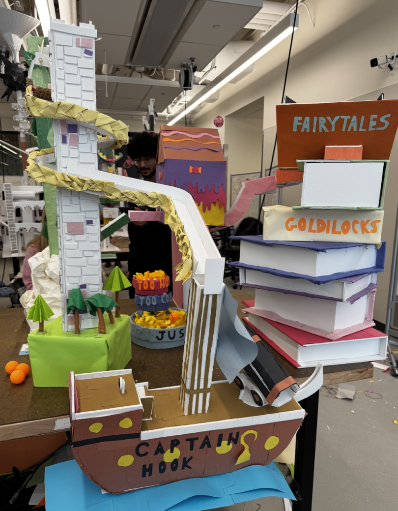 Image featuring a roller coaster built out of foam core. The rollercoaster features several elements from different fairy tales such as a stack of books, Hansel and Gretel's Candy House, Rapunzel's tower, Captain Hook's ship, and more. The roller coaster