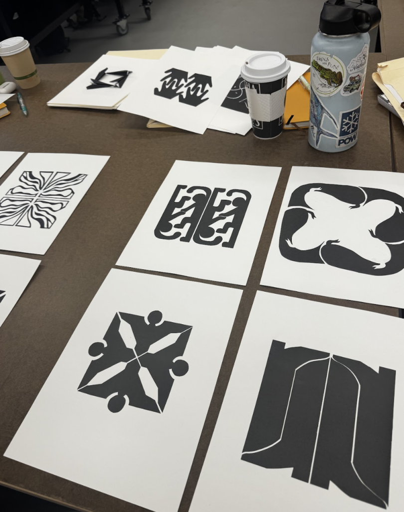 Image featuring several pieces of black paper glued on white paper to create the shape of a square. Each individual piece of white paper has a different design on it while maintaining the same form of a square