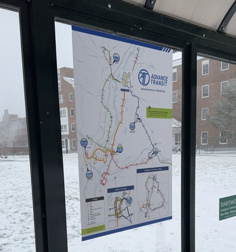 This image shows a map in a bus stop location which portrays all the different routes and stops the advanced transportation system connects in the upper valley. Several buildings can be seen covered in snow in the background. 