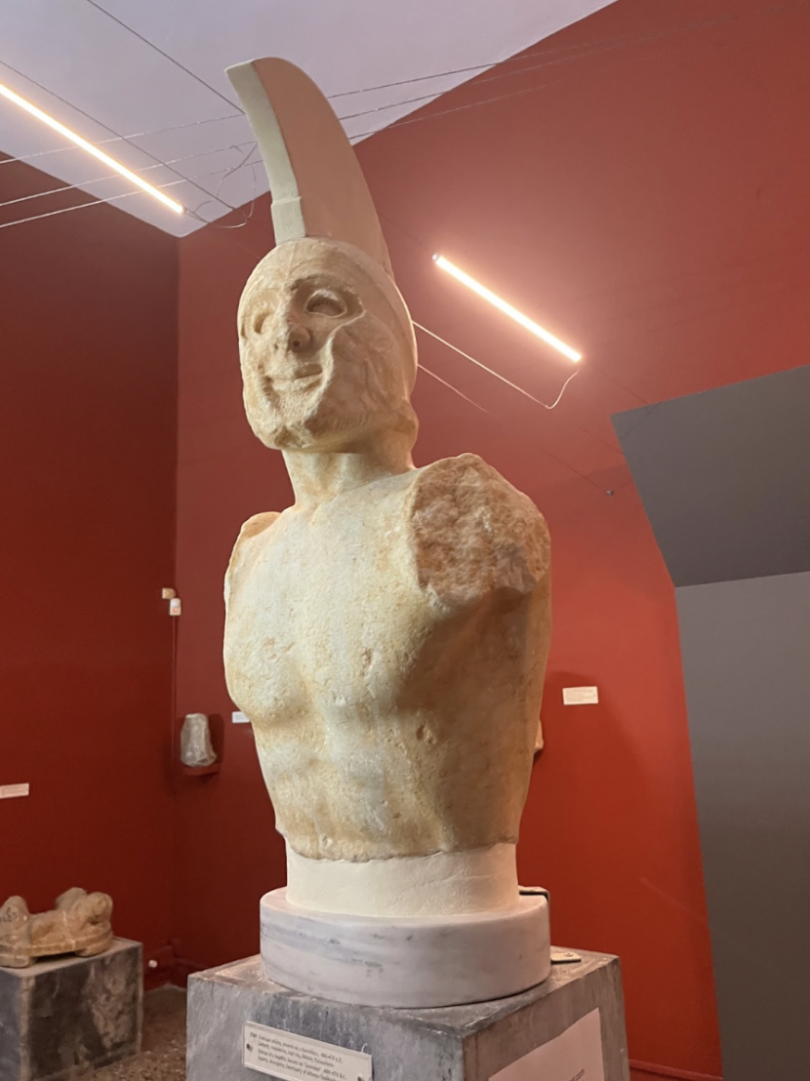 A marble statue with a red backdrop