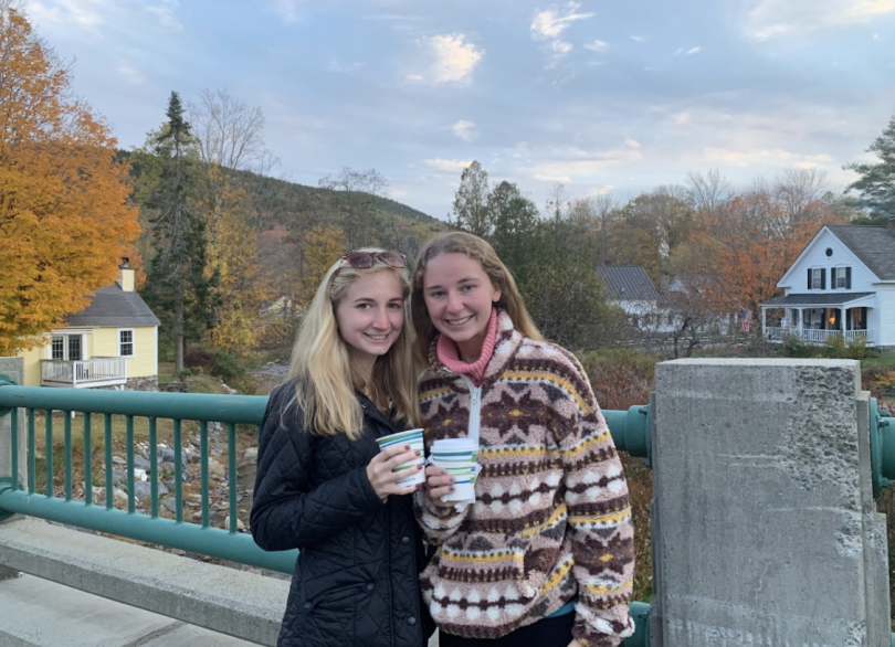 two girls stand on a bridge