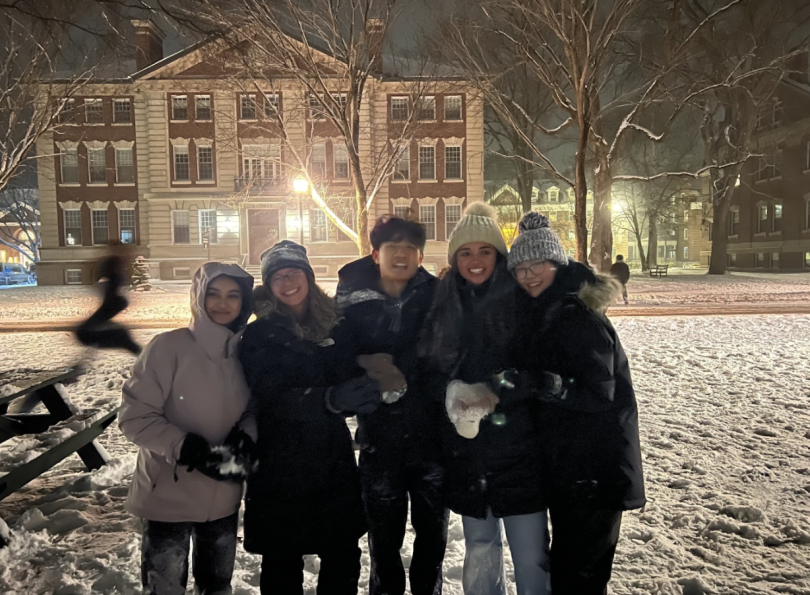 students covered in snow amidst a snowball fight. 